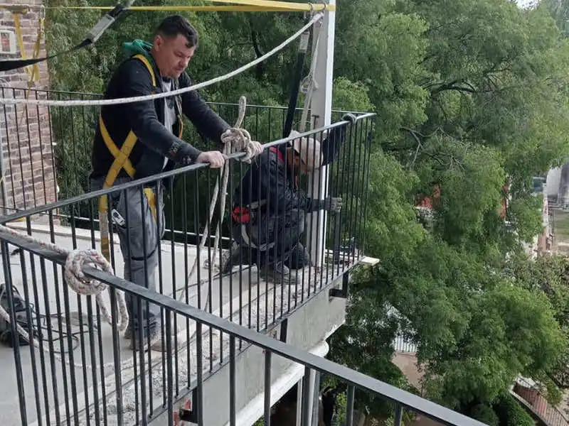 Restauraciones en obra en barandilla de balcón: trabajo exterior con seguridad