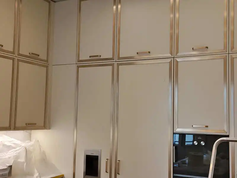 Restauraciones en obra en muebles de cocina con perfiles metálicos tipo latón y tiradores