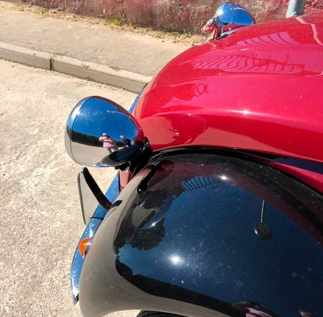 Restauración de vehículos: detalle de espejo cromado y carrocería con acabado brillante